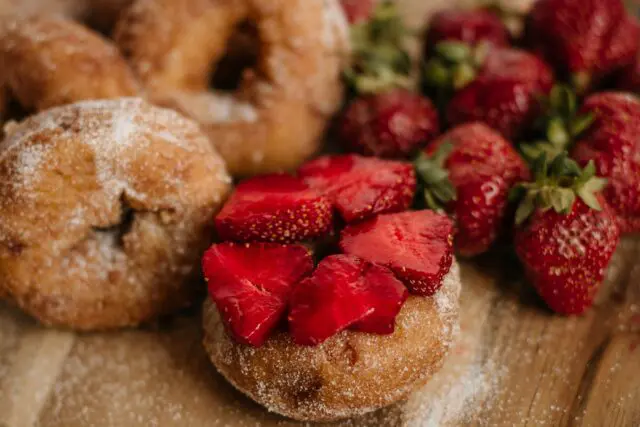Cider donut with Strawberries close up on a wood table.