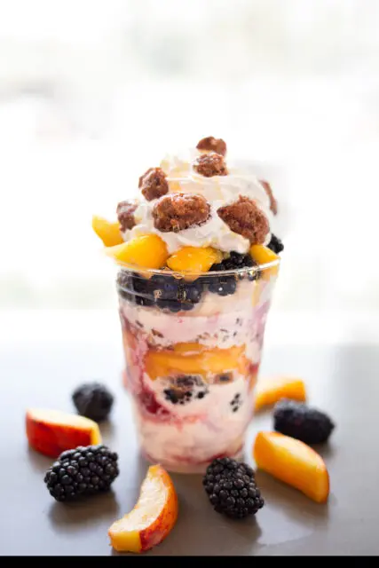 Vanilla Cutard topped with fresh sliced peches, and blackberries