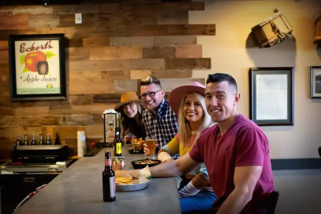 A picture of people at eating food at the restaurant bartop