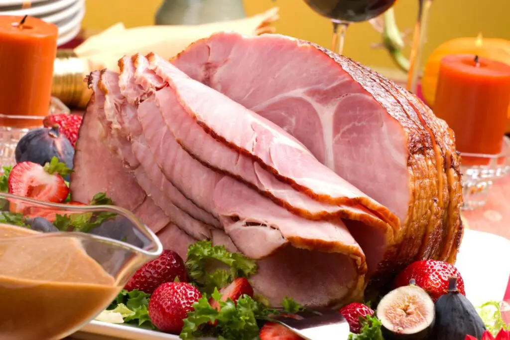 A picture of sliced ham with holiday decor surroundings