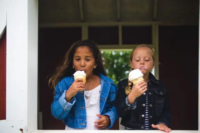 Two Children Eating Ice Cream cones outside