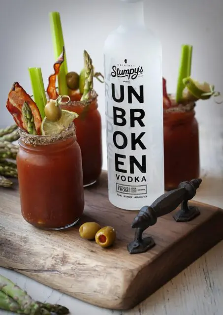 Three Bloody Mary made with Stumpy's Unbroken Vodka on wooden tray.