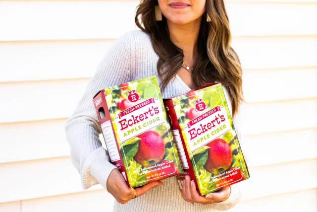 Eckert's Apple Cider - woman holding 2 containers of Apple Cider