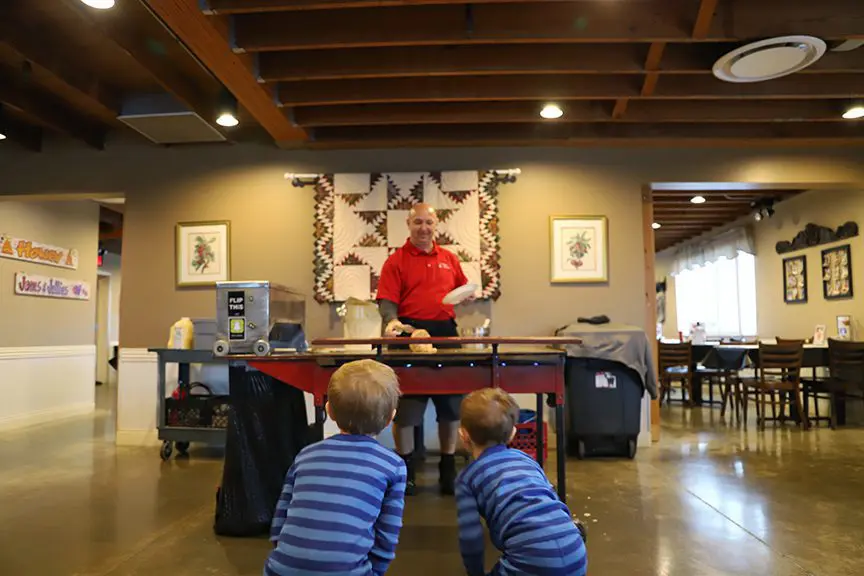Pancakes & Pajamas - man flipping pancakes on griddle and entertaining the two boys.