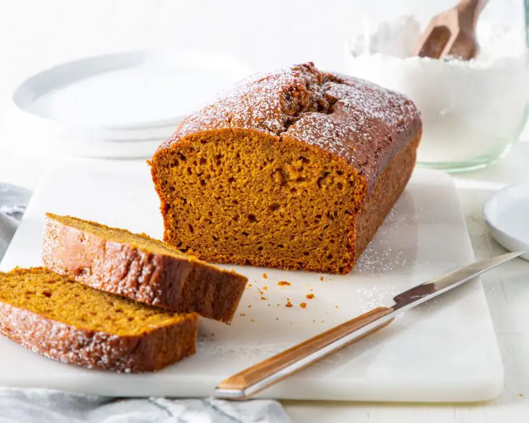 Pumpkin Bread sliced on a cutting board with knife.