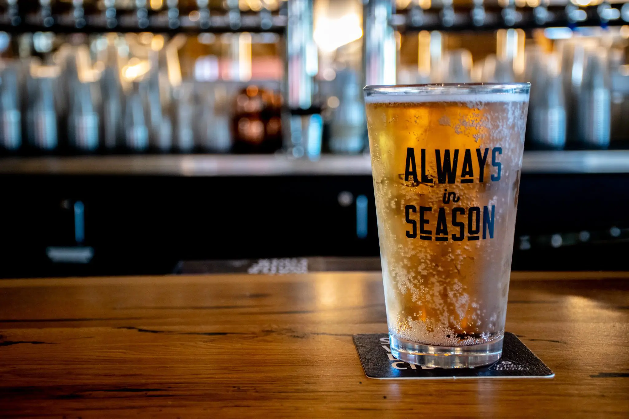 Pint of Hard Cider on bar in Cider shed. Glass states " always in season'.