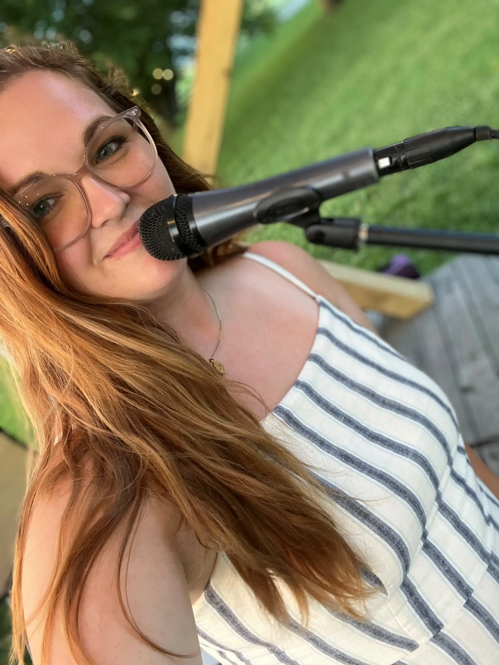 Cider Shed Live Music; Maggie Thorn close up at microphone outdoors.