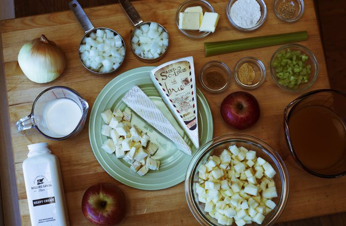 Various cooking ingredients are neatly organized on a wooden table, including dairy, flour, fruits, vegetables, and seasonings.