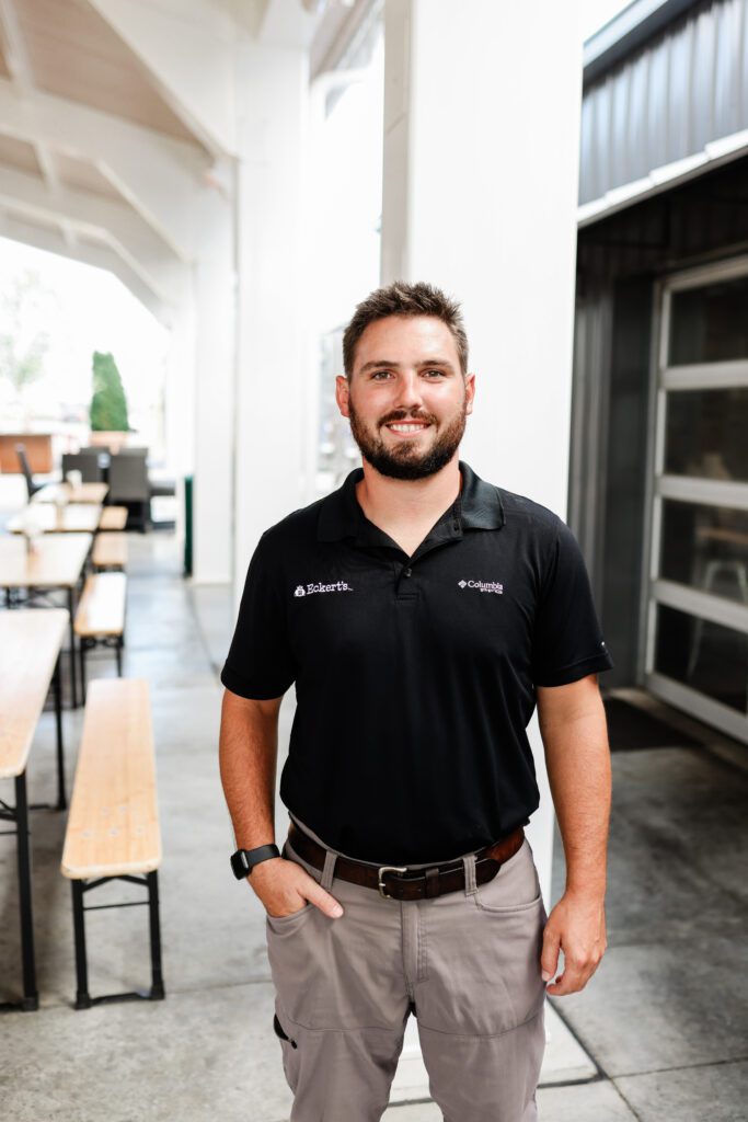 Farm Operations Manager, Jack Lanxon, standing outside of a building and smiling